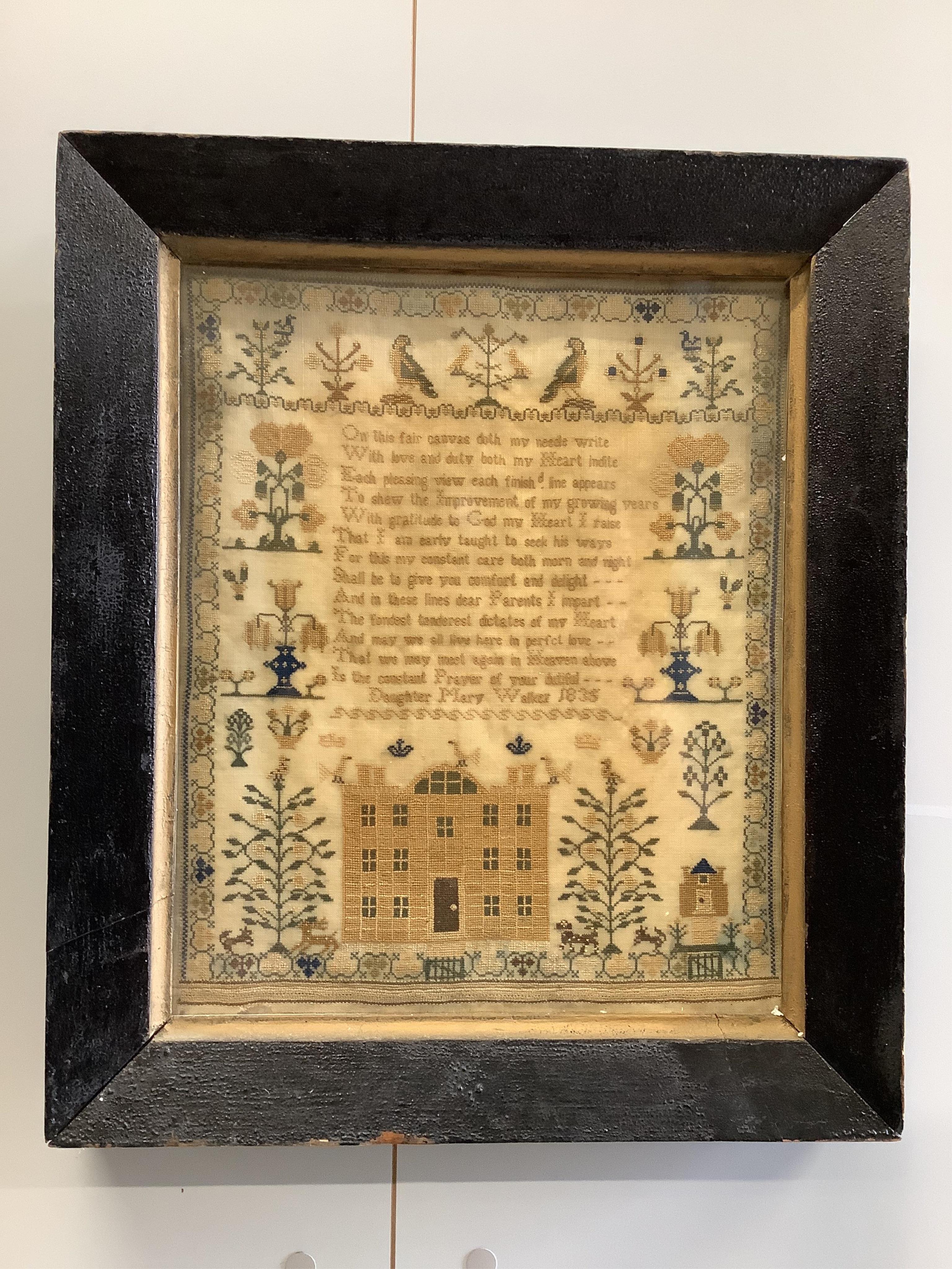 A framed 1835, dated sampler, embroidered by Mary Walker, worked in fine coloured silks, with a central verse and large three storey house, trees, dogs, deer and rabbits, below a panel of embroidered trees, flowers and b